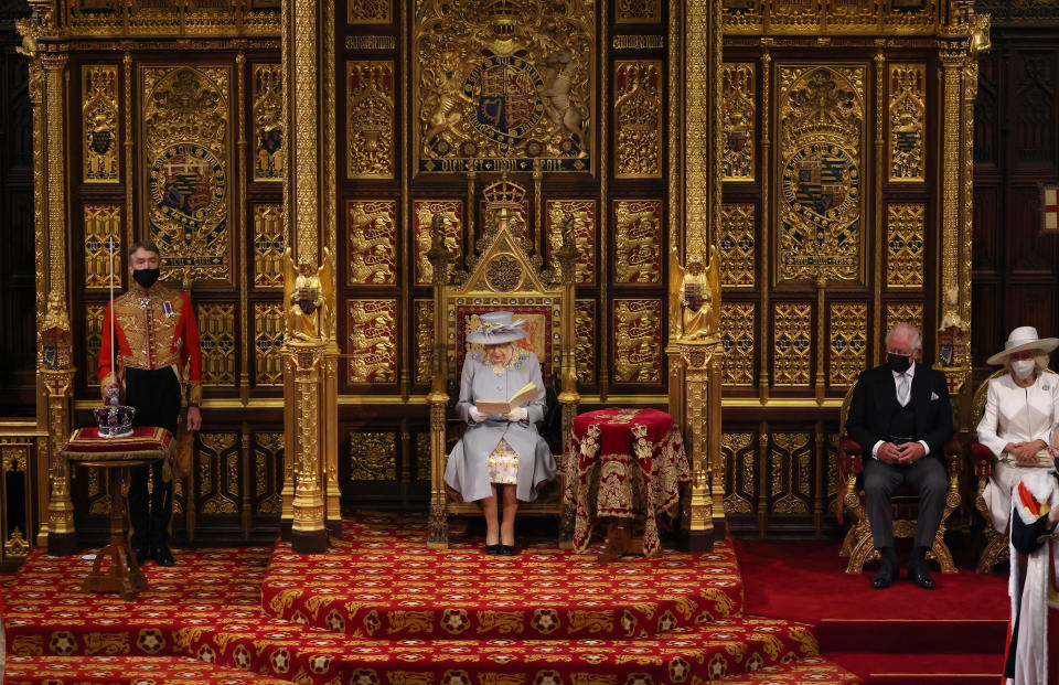 The Prince of Wales and the Duchess of Cornwall seated by Queen Elizabeth II as she delivers a speech from the throne in House of Lords at the Palace of Westminster in London as she outlines the government's legislative programme for the coming session during the State Opening of Parliament. Picture date: Tuesday May 11, 2021.