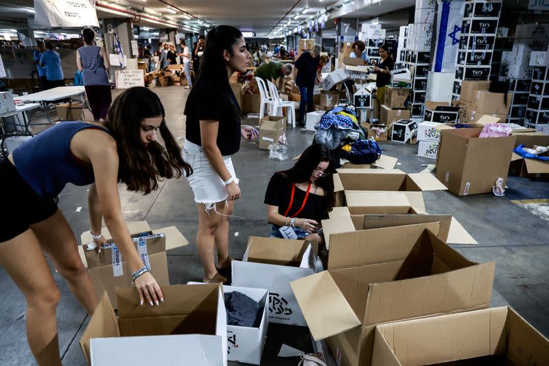 Volunteers pack boxes of donated humanitarian supplies at a logistical centre to support those impacted by the deadly infiltration by Hamas gunmen from the Gaza Strip, in Tel Aviv