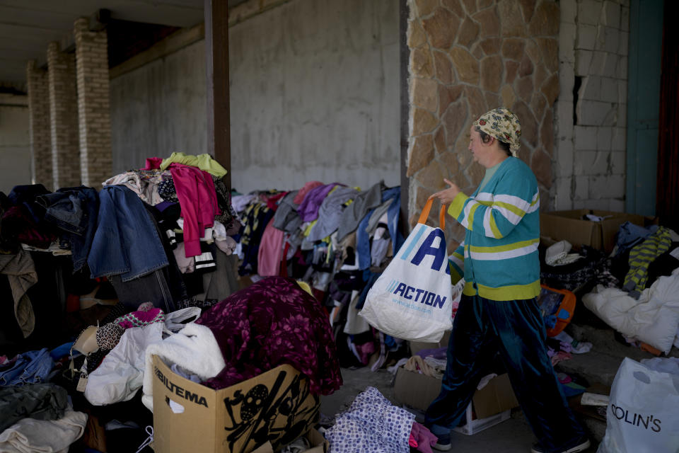 Maria Kocherzynska brings clothes to donate in Moschun, on the outskirts of Kyiv, Ukraine, Monday, June 6, 2022. (AP Photo/Natacha Pisarenko)