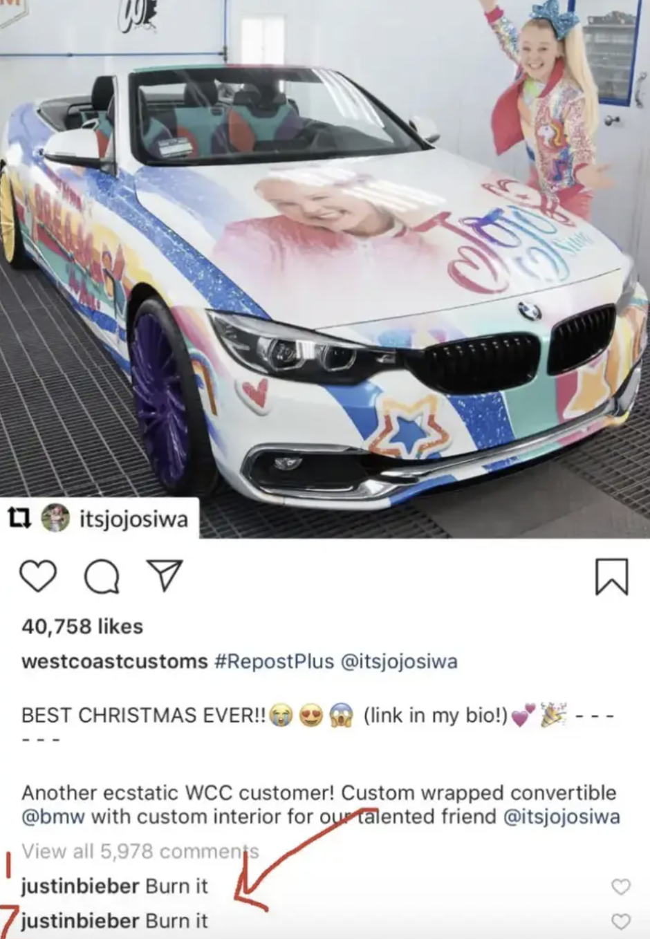 A screenshot of an Instagram post where Jojo Siwa is posing in front of a very brightly colored car that has her face and name on the hood, there are two comments from Justin Bieber reading 'Burn it'