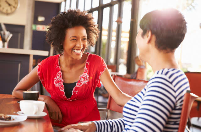 Two female friends talking at a coffee shop