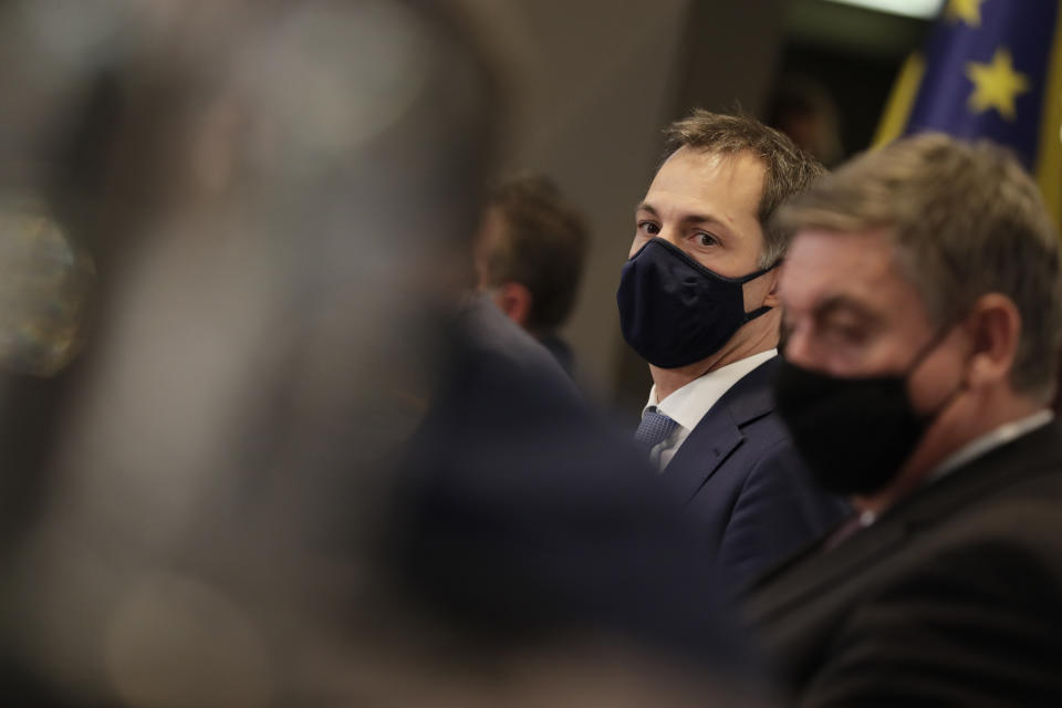 FILE - In this Friday, Oct. 16, 2020 file photo, Belgium's Prime Minister Alexander De Croo, center, waits for the start of a media conference, after a committee to discuss new restrictive measures regarding coronavirus, COVID-19, in Brussels. Small, yet so divided, Belgium is hit hard again by the pandemic, and now has some of the worst results to show in Europe during the resurgence of the Coronavirus, it is revealed Tuesday Oct. 27, 2020. (Stephanie Lecocq, Pool via AP, File)