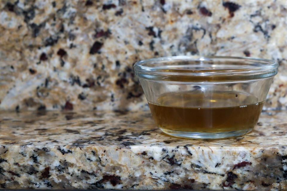 A glass jar of vinegar on a kitchen counter to attract gnats and flies.