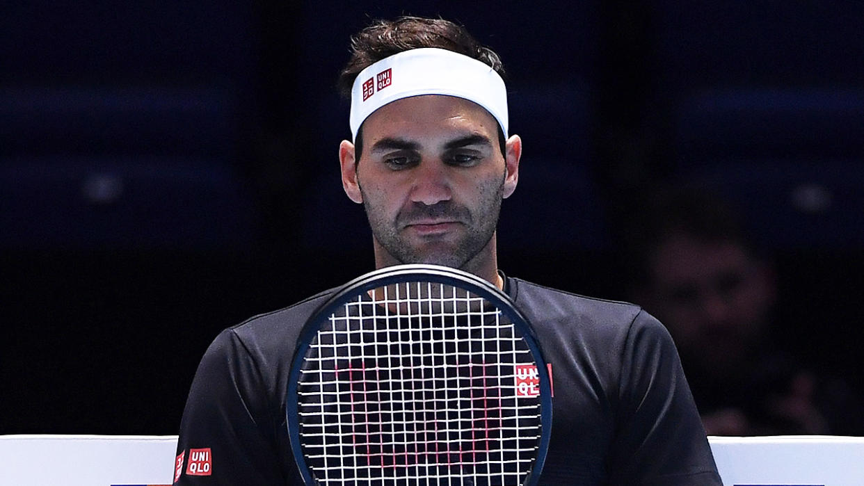 Roger Federer inspecting his racket at practice.