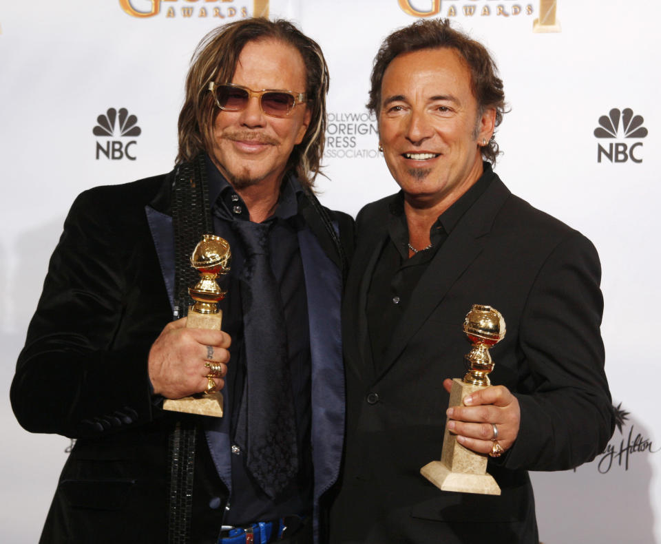 Singer Bruce Springsteen (R) holds his Golden Globe award for Best Song "The Wrestler" in the film "The Wrestler" with Mickey Rourke, holding his award for Best Performance by an Actor in a Motion Picture - Drama for "The Wrestler", at the 66th annual Golden Globe awards in Beverly Hills, California January 11, 2009. REUTERS/Lucy Nicholson (UNITED STATES)