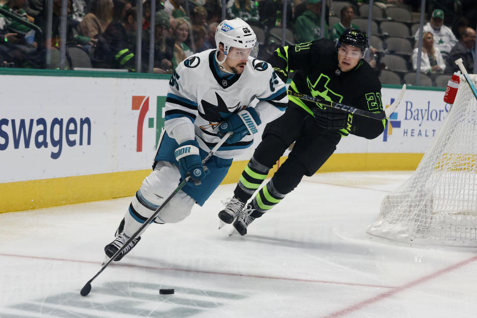 San Jose Sharks defenseman Erik Karlsson (65) pushes the puck past Dallas Stars left wing Jason Robertson (21) during the first period of an NHL hockey game in Dallas, Saturday, Dec. 31, 2022. (AP Photo/Michael Ainsworth)