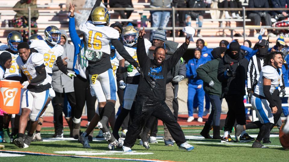 Woodbury High School's head football coach Anthony Reagan, center, celebrates with his players after Woodbury defeated Salem,   22-7, in the state Group 1 football semifinal game played at Cherokee High School in Marlton on Saturday, November 19, 2022.  