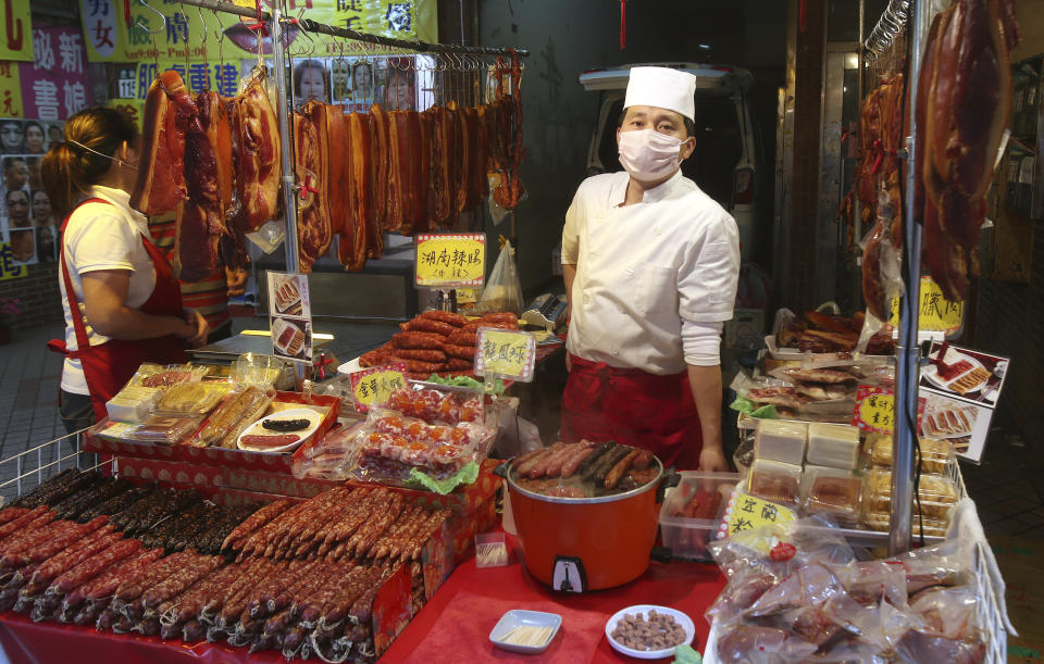 A vendor wears a face masks to help curb the spread of the coronavirus at his shop at a market in Taipei, Taiwan, Monday, Jan. 25, 2021. (AP Photo/Chiang Ying-ying)