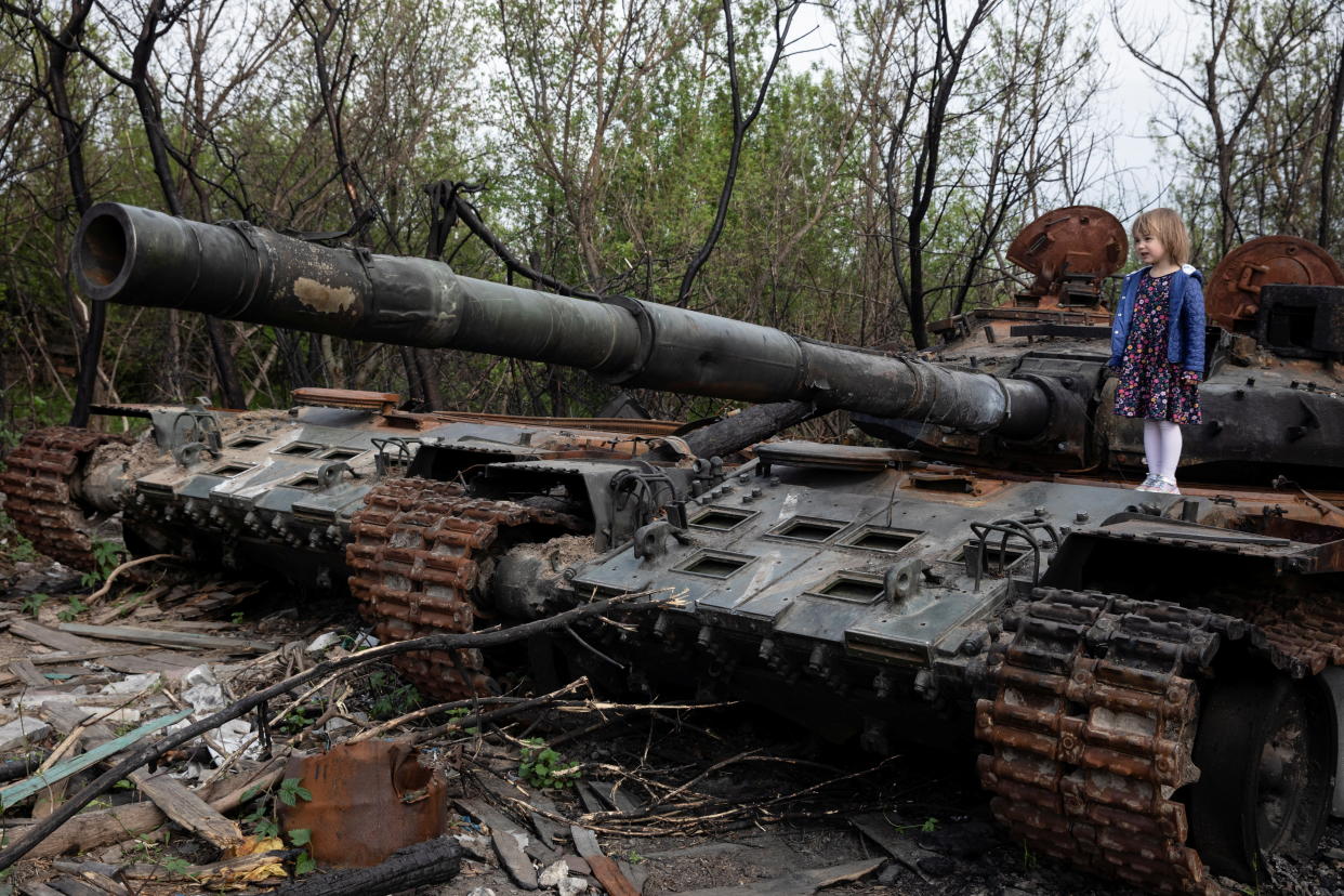 A child stands on a destroyed Russian tank, amid Russia's invasion of Ukraine, near Makariv, Kyiv region, Ukraine May 7, 2022. REUTERS/Mikhail Palinchak