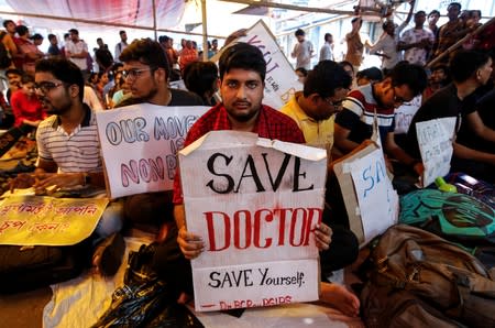 A doctor holds a placard at a government hospital during a strike demanding security after the recent assaults on doctors by the patients' relatives, in Kolkata