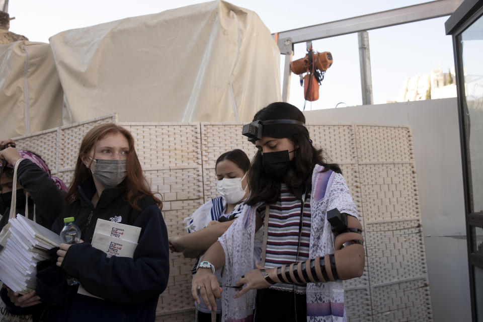 Members of the Women of the Wall wearing tefillin after the Rosh Hodesh, or new month prayer in the women's section at the Western Wall, the holiest site where Jews can pray, in the Old City of Jerusalem, Friday, Nov. 5, 2021. Thousands of ultra-Orthodox Jews gathered at the site to protest against the Jewish women's group that holds monthly prayers there in a long-running campaign for gender equality at the site. (AP Photo/Maya Alleruzzo)