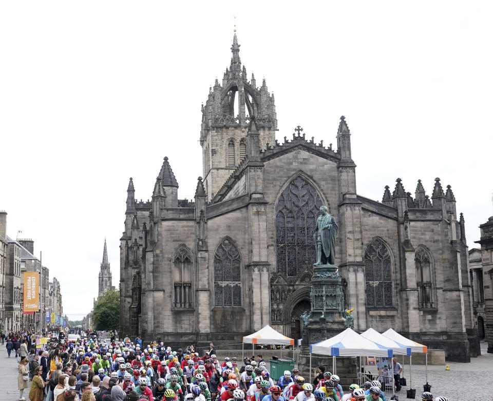 The peloton rolls past St Giles' Cathedral in Edinburgh at the start of the Men's Elite Road Race on day four of the 2023 UCI Cycling World Championships in Glasgow, Scotland, Sunday Aug. 6, 2023. (Tim Goode/PA via AP)
