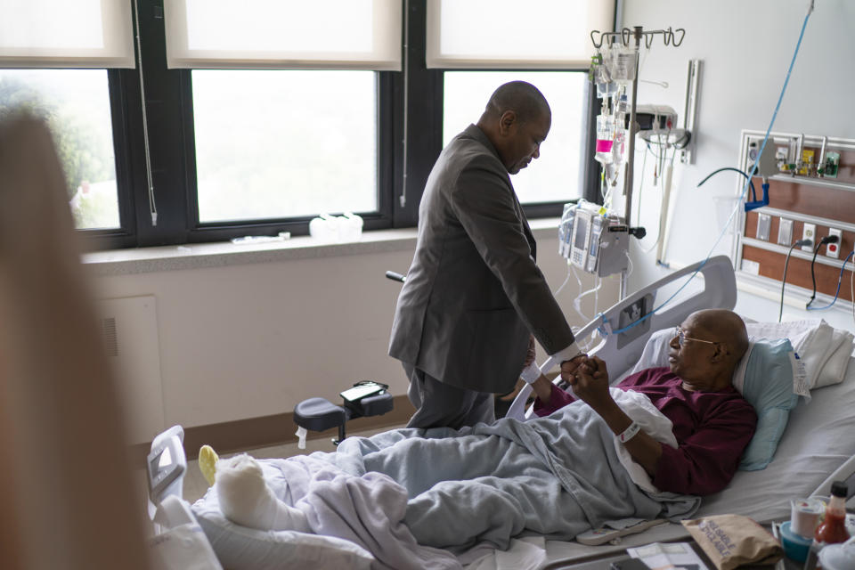 Rev. Jimmie Hardaway Jr., left, prays with, Rev. Charles Searcy, while visiting friends recovering in a hospital, Sunday, Aug. 20, 2023, in Buffalo, N.Y. (AP Photo/David Goldman)