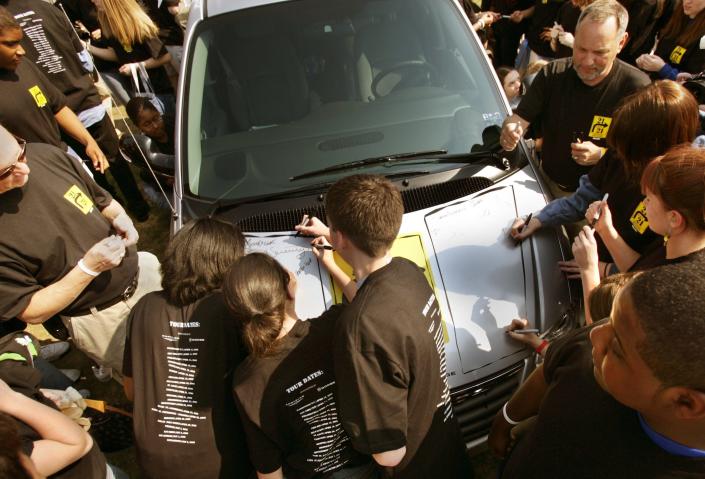 Students sign their pledge and name to one of the minivans parked outside of Ferndale High School in Ferndale on April 18, 2005.
