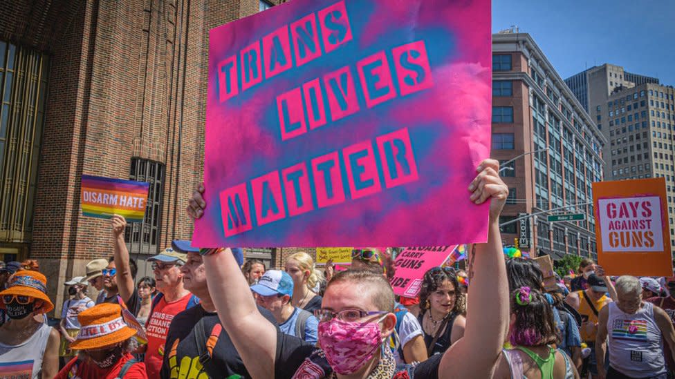 persona con un letreto protesta a favor de las personas trans en EE.UU.