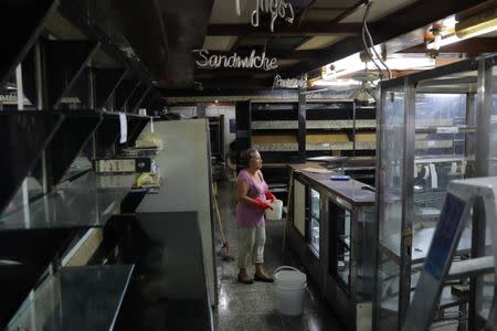 A woman stands inside of a bread and cake shop after looters broke in, following days of protest against Venezuelan President Nicolas Maduro in the city of Los Teques, near Caracas, Venezuela, May 19, 2017. REUTERS/Carlos Barria