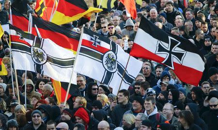 Supporters of anti-immigration right-wing movement PEGIDA (Patriotic Europeans Against the Islamisation of the West) carry various versions of the Imperial War Flag (Reichskriegsflagge) during a demonstration march, in reaction to mass assaults on women on New Year's Eve, in Cologne, Germany January 9, 2016. REUTERS/Wolfgang Rattay