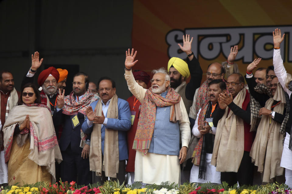 Indian Prime Minister Narendra Modi, center, waves to supporters at a rally of his Hindu nationalist Bharatiya Janata Party in New Delhi, India, Sunday, Dec. 22, 2019. Clashes continued Sunday between Indian police and protesters angered by a new citizenship law that excludes Muslims, as Modi used the rally to defend the legislation, accusing the opposition of pushing the country into a "fear psychosis." (AP Photo)