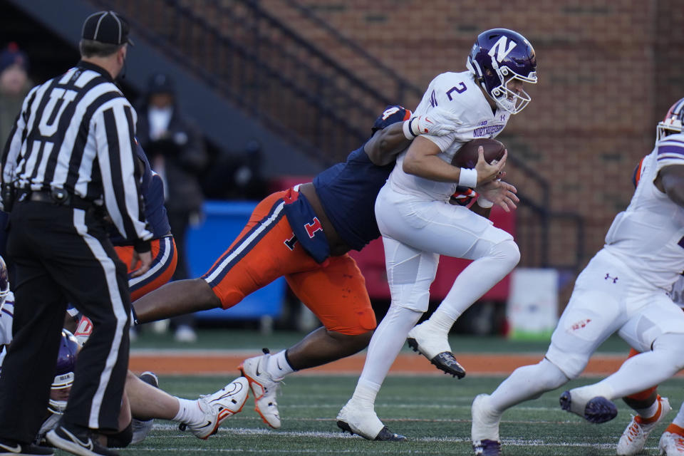 Northwestern quarterback Ben Bryant (2) is sacked by Illinois defensive lineman Jer'Zhan Newton, center left, during the first half of an NCAA college football game Saturday, Nov. 25, 2023, in Champaign, Ill. (AP Photo/Erin Hooley)