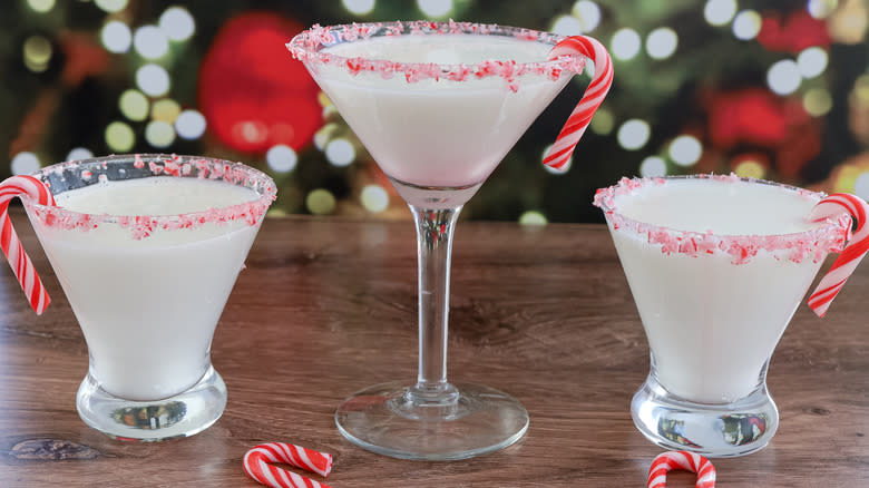 three candy cane martini cocktails on wooden table