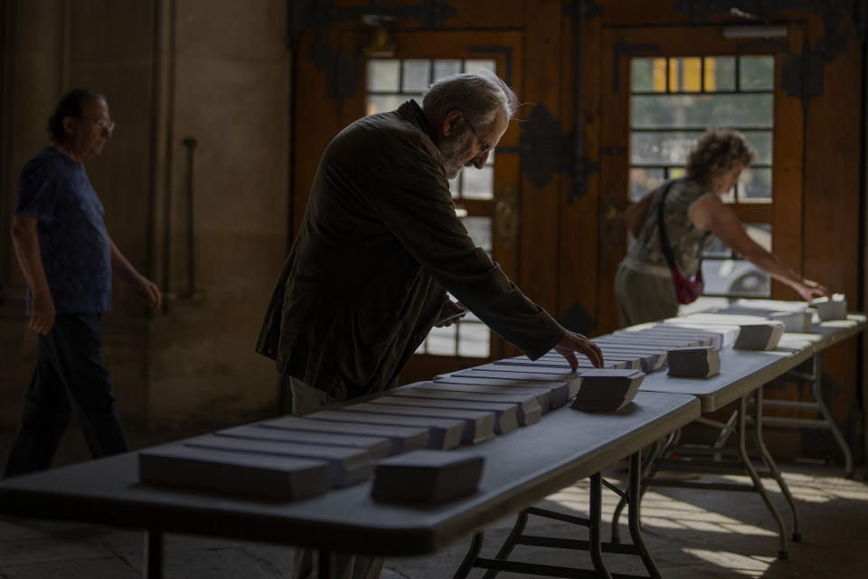 Gente eligiendo boletas para las elecciones parlamentarias en Barcelona, España, el domingo 9 de junio de 2024. Centros de votación de buena parte de la Unión Europea abrieron el domingo mientras los votantes de 20 países participaban en unas elecciones que se esperaba inclinaran el Parlamento Europeo a la derecha y que podrían cambiar el rumbo del bloque comercial más grande del mundo. (AP Foto/Emilio Morenatti)