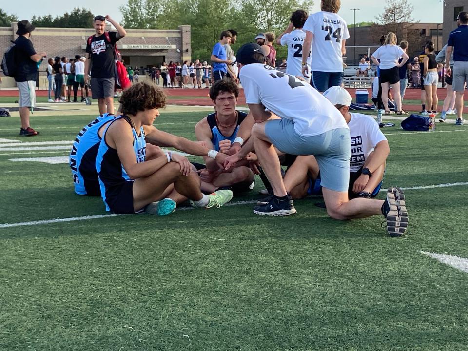 Members of Saint Joe's 4x100 team sit together with coach Mike McCarthy after completing an emotional race. [JUSTIN FROMMER/THE SOUTH BEND TRIBUNE]