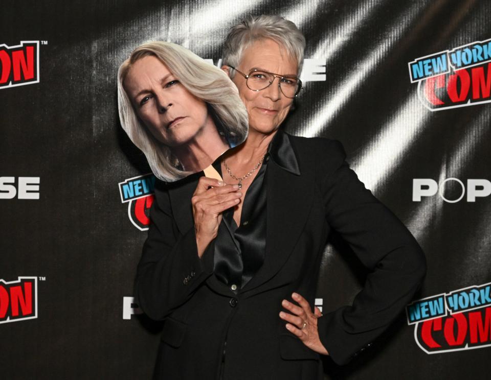 Jamie Lee Curtis poses with a picture of her "Halloween" heroine Laurie Strode at New York Comic Con.