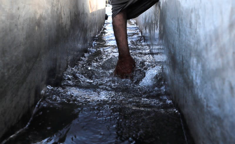 Abdel-Shaheed Gerges, a farmer, touches water at an irrigation channel developed by a government project in Comer village in Esna, south of Luxor