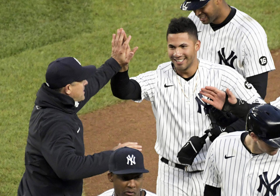 El venezolano Gleyber Torres es felicitado por el manager Aaron Boone luego de producir la carrera de la victoria sobre los Nacionales de Washington, en la undécima entrada del juego del sábado 8 de mayo de 2021 (AP Foto/Bill Kostroun)