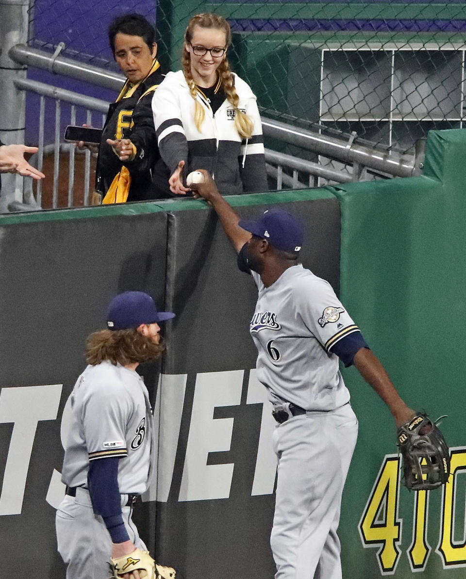 Milwaukee Brewers center fielder Lorenzo Cain (6) hands the ball to a fan after making the catch on a long fly ball to center field by Pittsburgh Pirates' Josh Bell to end a baseball game in Pittsburgh, Thursday, May 30, 2019. The Brewers won 11-5. (AP Photo/Gene J. Puskar)