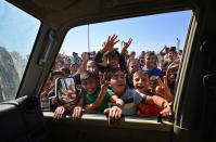 <p>Iraqi boys gather on the road as they welcome Iraqi security forces members, who continue to advance in military vehicles in Kirkuk, Iraq, Oct. 16, 2017. (Photo: Stringer/Reuters) </p>