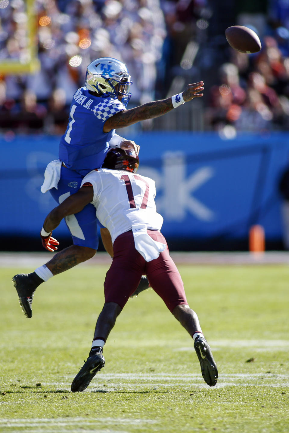 Kentucky quarterback Lynn Bowden Jr. (1) passes as he is hit by Virginia Tech defensive back Divine Deablo (17) in the first half of the Belk Bowl NCAA college football game in Charlotte, N.C., Tuesday, Dec. 31, 2019. (AP Photo/Nell Redmond)