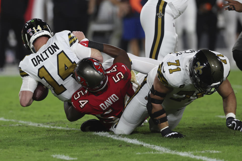 Tampa Bay Buccaneers linebacker Lavonte David (54) brings down New Orleans Saints quarterback Andy Dalton (14) in the first half of an NFL football game in Tampa, Fla., Monday, Dec. 5, 2022. (AP Photo/Mark LoMoglio)