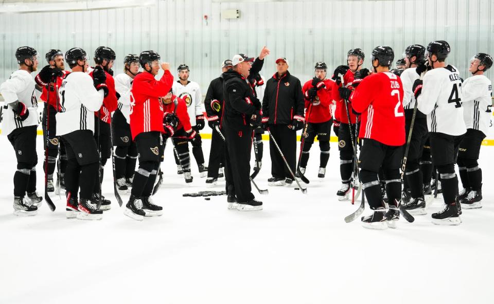 Ottawa Senators head coach D.J. Smith, centre, talks to his players during training camp Sept. 21, 2023.