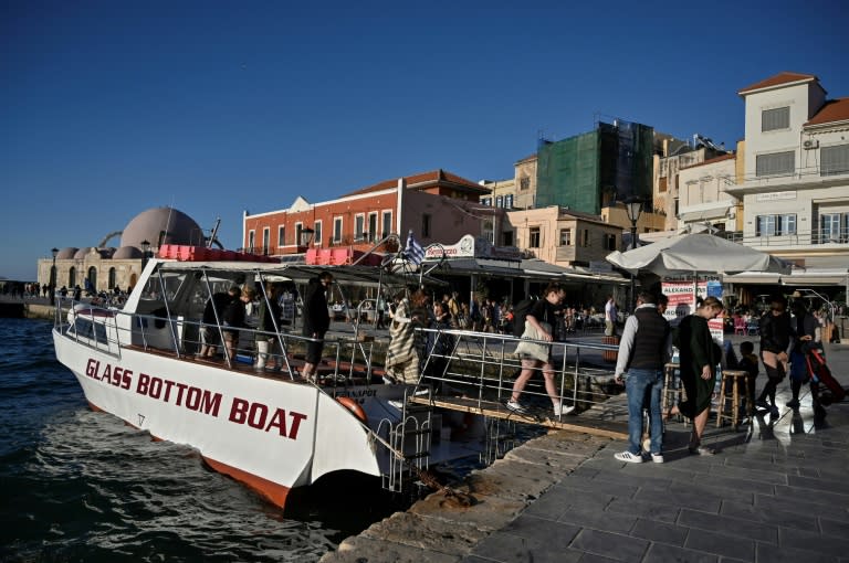 Des touristes débarquent à La Canée, en Crète, après un tour en bateau, le 20 avril 2022 (AFP/Louisa GOULIAMAKI)