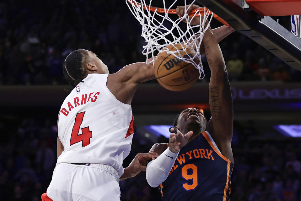 New York Knicks guard RJ Barrett (9) dunks in front of Toronto Raptors forward Scottie Barnes (4) at the end of the second half of an NBA basketball game Monday, Jan. 16, 2023, in New York. (AP Photo/Adam Hunger)