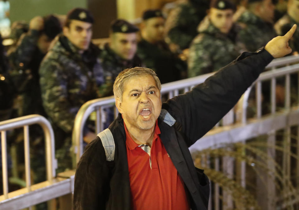 An anti-government protester shouts slogans, during ongoing protests against the ruling elite of corruption and financial crisis, in downtown Beirut, Lebanon, Wednesday, Dec. 18, 2019. Lebanon's caretaker prime minister said Wednesday he's no longer a candidate for the post, eliminating himself from consideration on the eve of scheduled consultations between the president and parliamentary blocs for naming a new premier. (AP Photo/Hussein Malla)