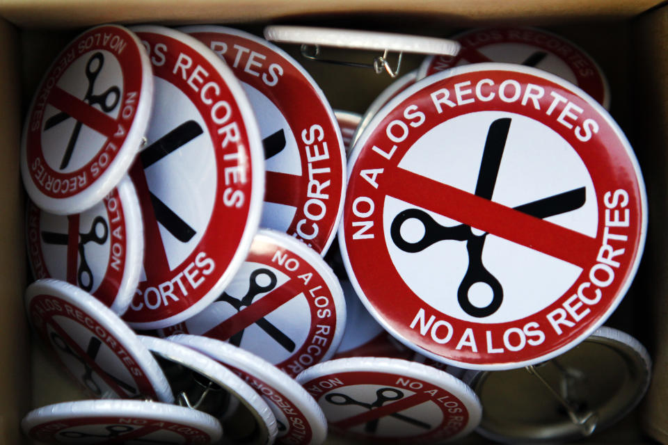 Badges for sale reading "No financial cuts" are seen during a protest against government financial cuts and the €23.5 billion bailout of lender Bankia, in Madrid, Spain, Sunday, July 29, 2012. (AP Photo/Andres Kudacki)