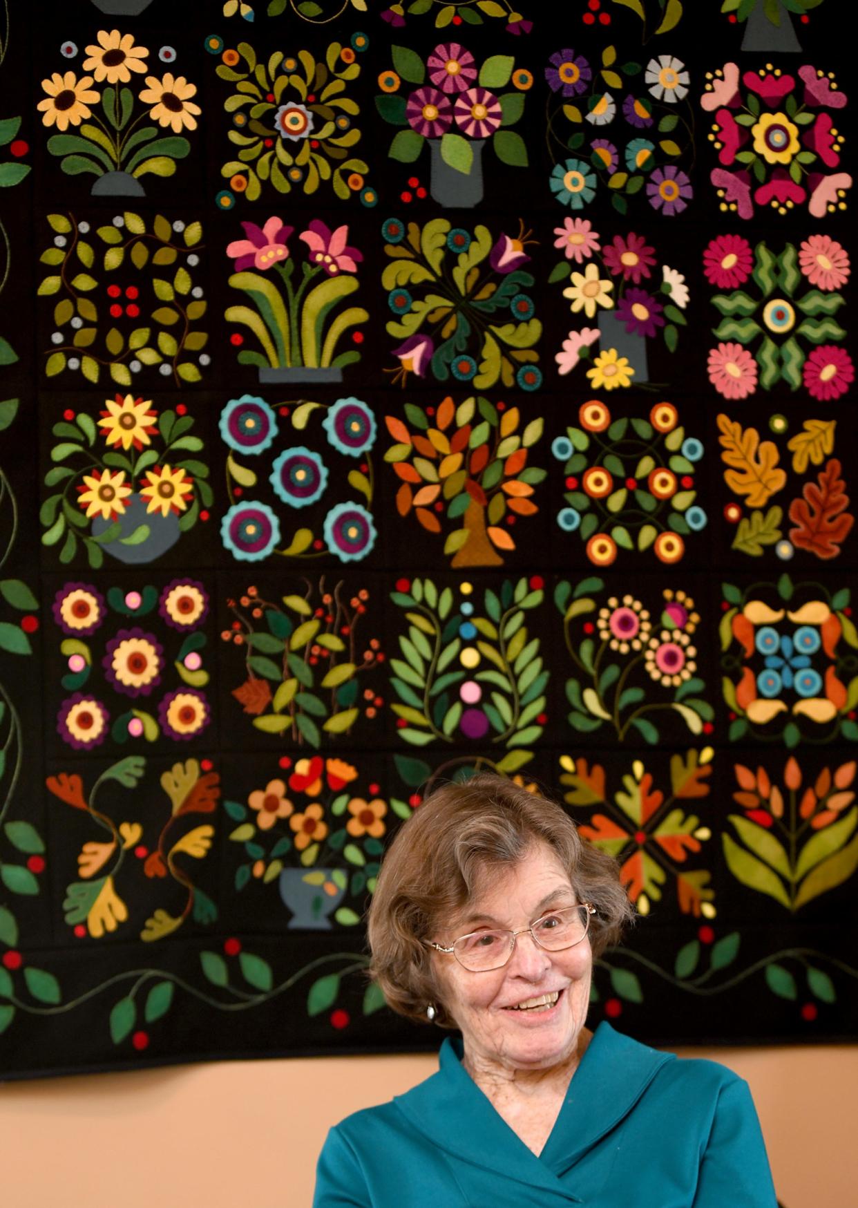 Sherry Carpenter talks about her time in Canton Quilters Guild as they celebrates its 25th anniversary. The quilt on the wall was made by Judy Stump. Thursday, April 28, 2022.