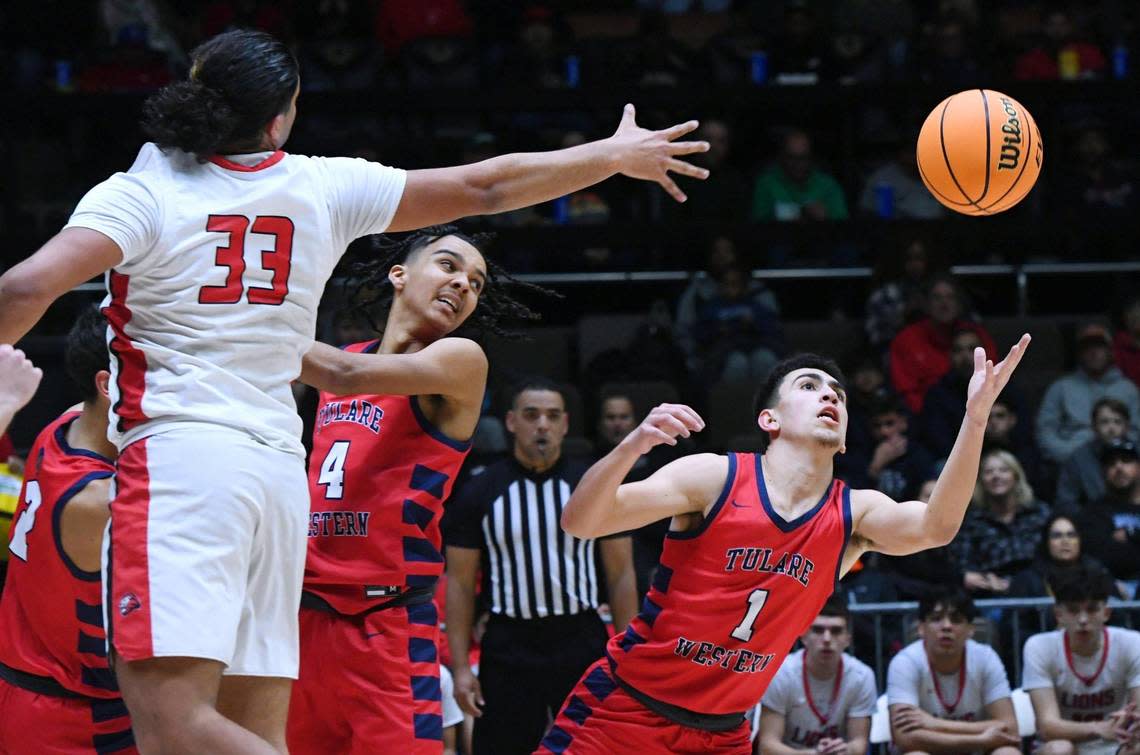 Tulare Western’s Carsin Boren, center, and Carmine Ficher, right, eye the loose bakk with Kerman’s Maximus Minnite to the left at the CIF Central Section Division IV basketball championship Friday, Feb. 24, 2023 in Fresno. Tulare Western won 60-40.