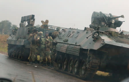 Soldiers stand beside military vehicles just outside Harare, Zimbabwe, November 14, 2017. REUTERS/Philimon Bulawayo