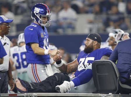 Sep 16, 2018; Arlington, TX, USA; New York Giants quarterback Eli Manning (10) talks to offensive guard Jon Halapio (75) as he is carted off the field after being injured in the third quarter against Dallas Cowboys at AT&T Stadium. Mandatory Credit: Tim Heitman-USA TODAY Sports