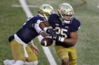 Notre Dame running back Chris Tyree (25) fumbles the ball on a handoff from quarterback Ian Book during the first half of an NCAA college football game against Boston College, Saturday, Nov. 14, 2020, in Boston. (AP Photo/Michael Dwyer)