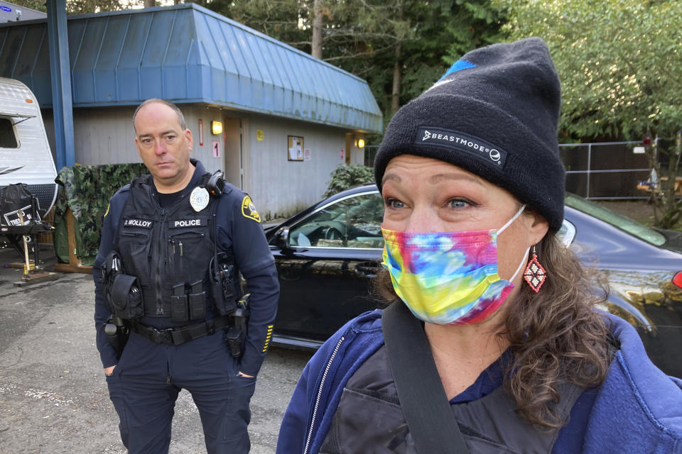 Lynnwood police Officer Denis Molloy, left, stands with Heather Turner, right, a mental health clinician from the behavioral health nonprofit Compass Health, outside a hygiene center for people experiencing homelessness, Wednesday, Nov. 17, 2021, in Lynnwood, Wash. Molloy, of the Lynnwood Police Department's community health and safety section, says that navigating recent police reforms in Washington State has been challenging. (AP Photo/Gene Johnson)