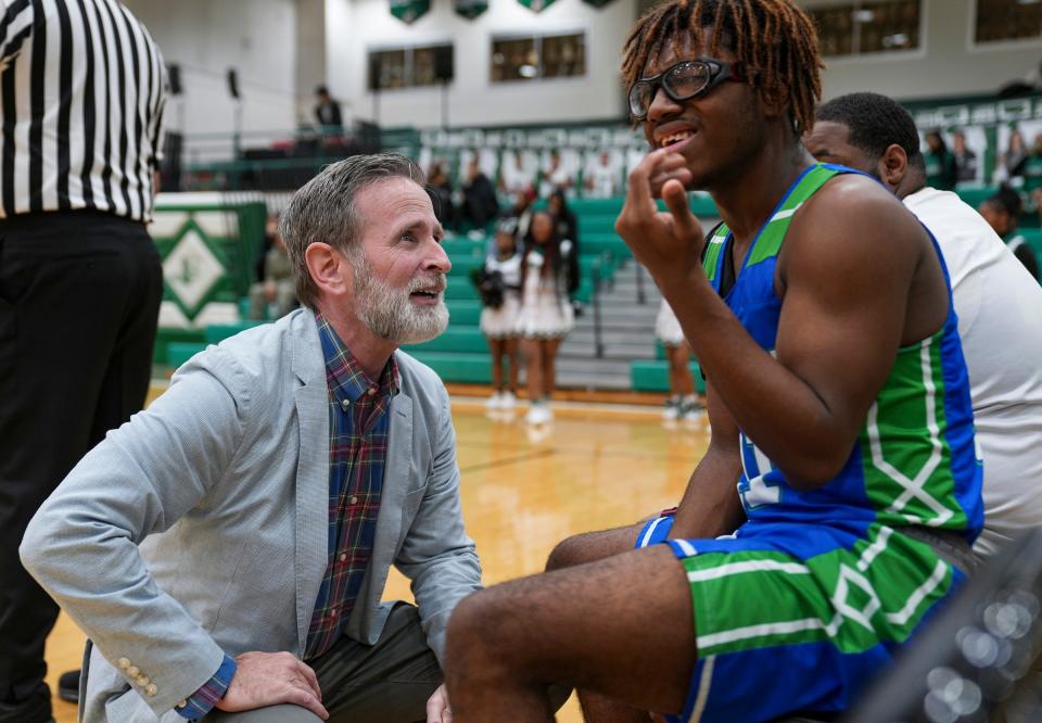 Providence Cristo Rey head coach Scott Miller talks with junior Jason Morris after Morrs broke his front teeth in gameplay Tuesday, Jan. 16, 2024, at Arsenal Technical High School. "I am super passionate about developing young people and seeing them get better as people and as human beings," Miller said. "And if basketball happens to be the tool that we use to do that, so be it."