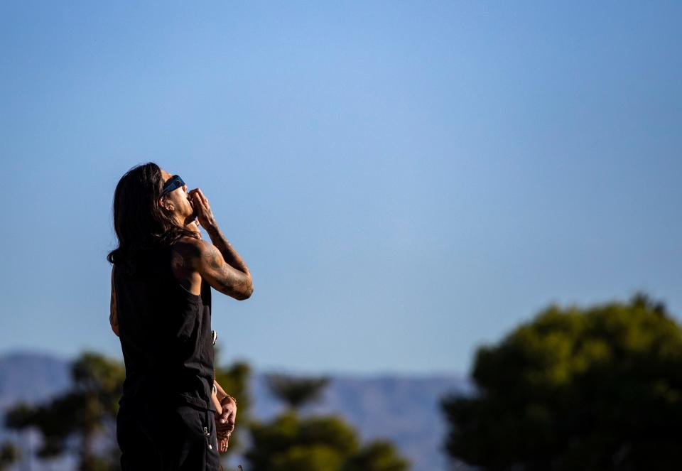 A person views the partial solar eclipse after picking up solar viewing glasses at the Rancho Mirage Library and Observatory in Rancho Mirage, Calif., Saturday, Oct. 14, 2023.