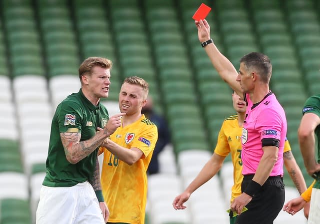 Referee Anastasios Sidiropoulos shows a red card to Ireland’s James McClean