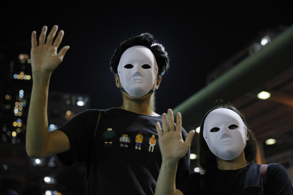 Masked protesters hold up their hands to represent their five demands in Hong Kong on Saturday, Oct. 5, 2019. All subway and train services were suspended, lines formed at the cash machines of shuttered banks, and shops were closed as Hong Kong dusted itself off and then started marching again Saturday after another night of rampaging violence decried as "a very dark day" by the territory's embattled leader. (AP Photo/Kin Cheung)