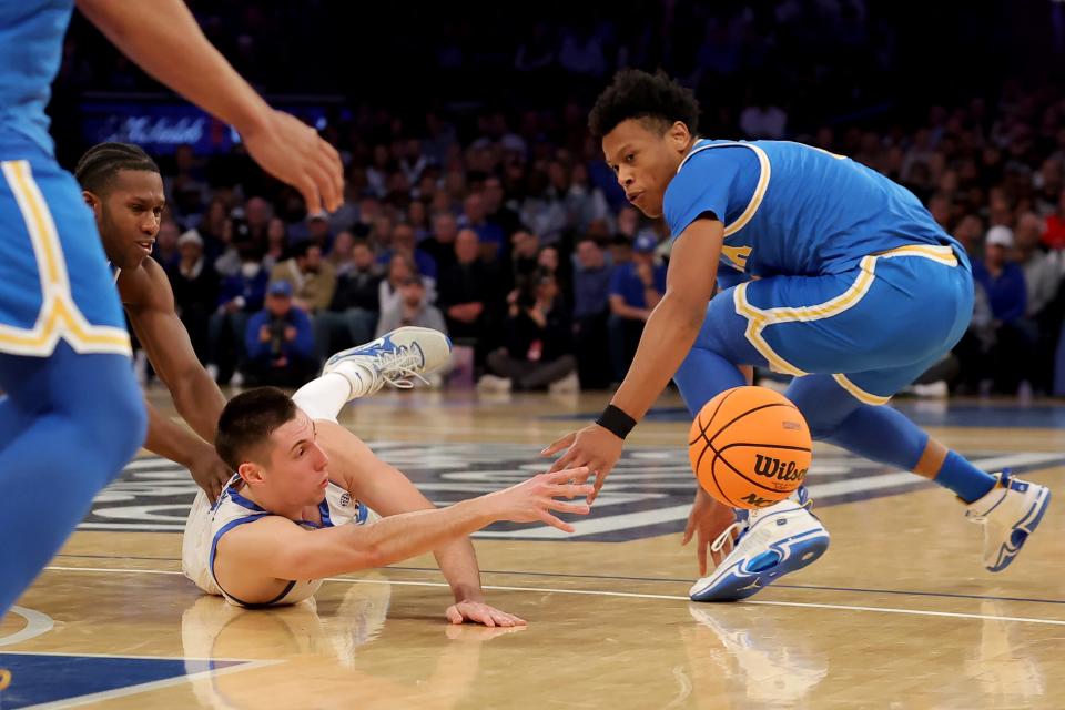 Dec 17, 2022; New York, New York, USA; Kentucky Wildcats guard CJ Fredrick (1) loses control of the ball as he slips and falls against UCLA Bruins guard David Singleton (34) and guard Jaylen Clark (0) during the first half at Madison Square Garden. Mandatory Credit: Brad Penner-USA TODAY Sports