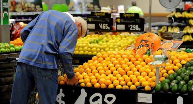 A shopper inspects fruit inside a Woolworths grocery store in Brisbane.